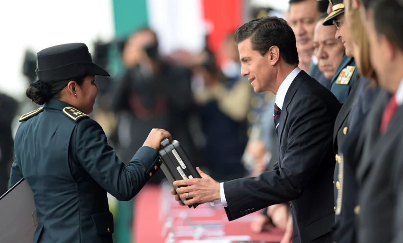 the man is giving soing to a soldier while shaking his hand