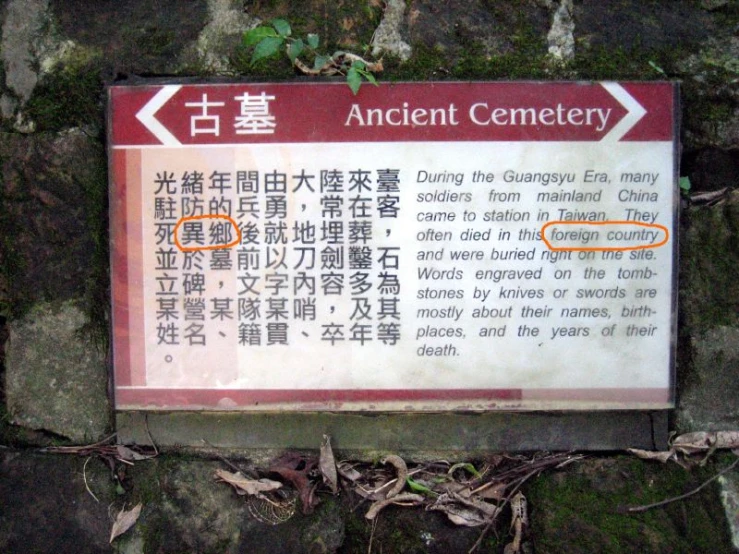 a sign posted on a large rock with other signs