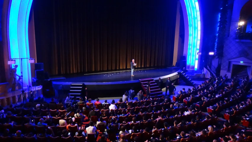 a po taken from the front seat of an auditorium with a stage set full of people