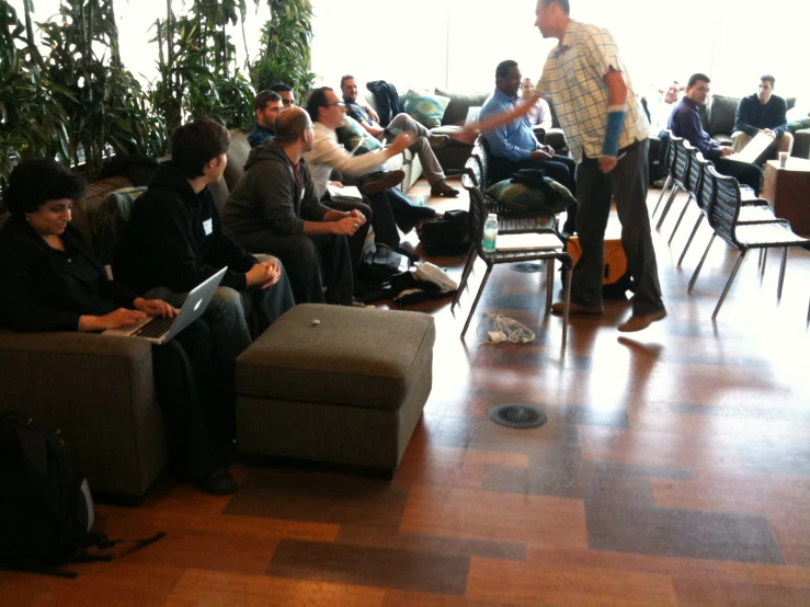 a large group of people sitting and standing around tables