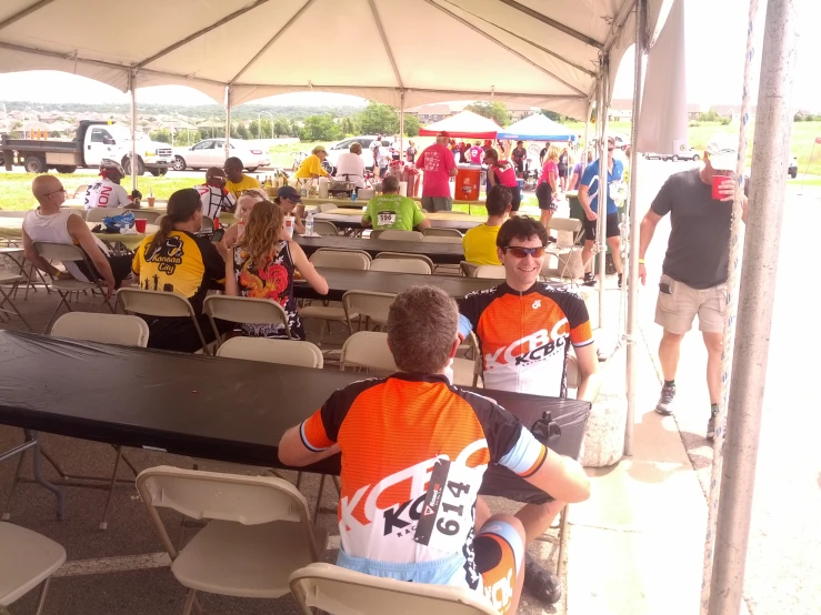 a number of people sitting at a long black table