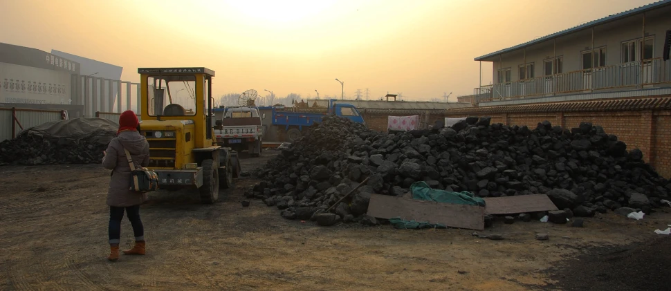 a person standing on a construction site holding a back pack