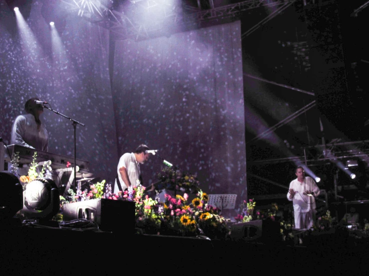 two musicians and one drummer are performing at the concert