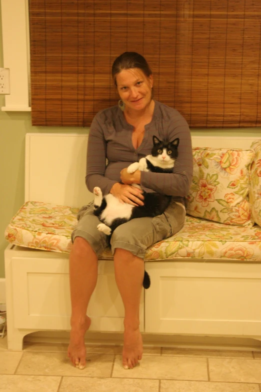 there is a woman sitting on a bench with two cats