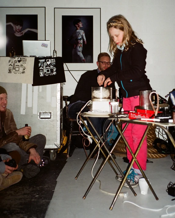 an adult watches a little girl blow out her candle