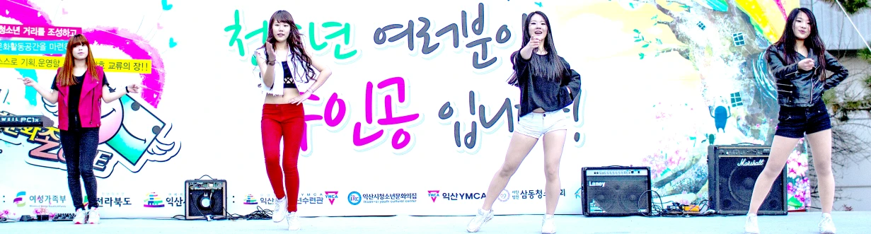 three young ladies are posed by some billboard