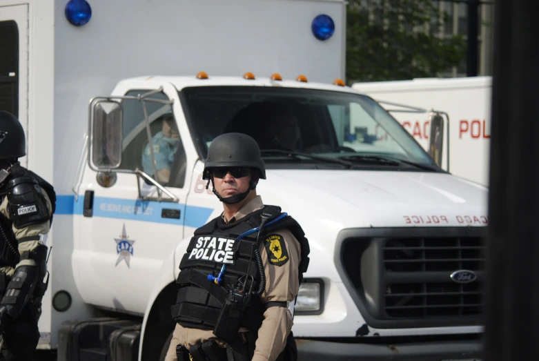 police standing in front of an ambulance and truck