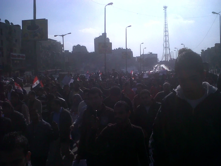 large crowd of people walking down a city street