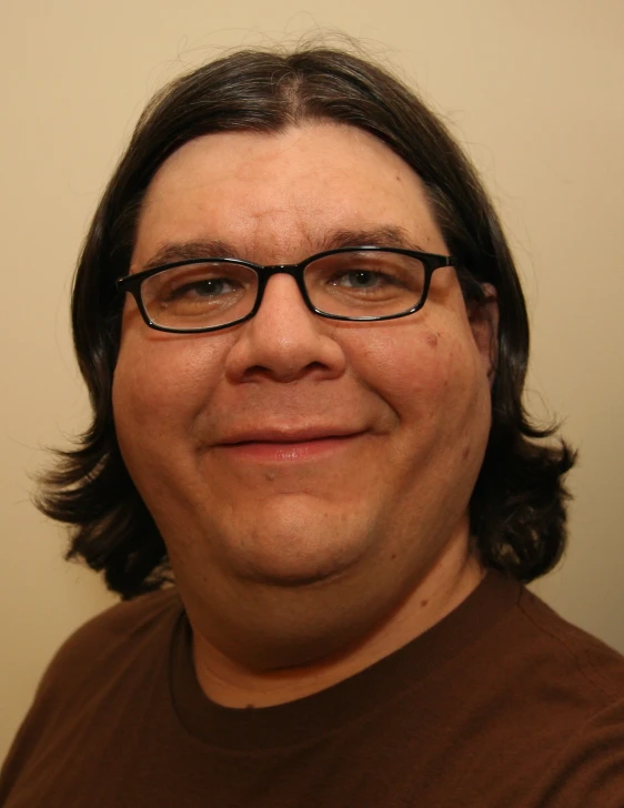 a close up of a man with glasses looking at the camera