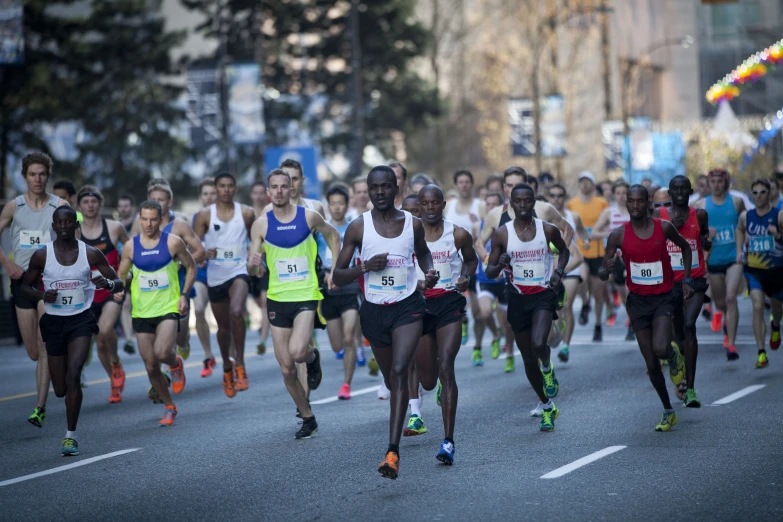 many people running on a street near trees