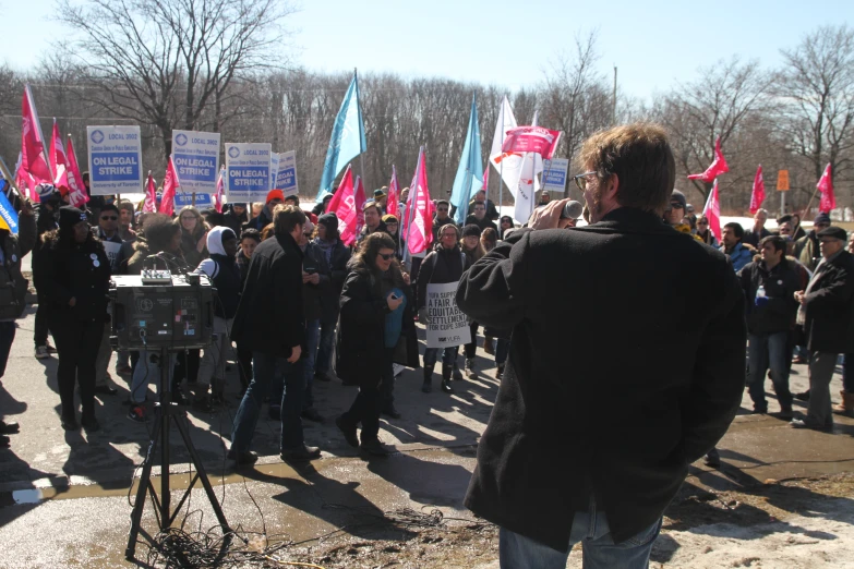 a crowd of people standing around each other holding signs