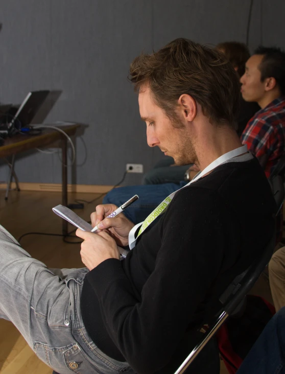 man sitting on a chair with cell phone in his lap