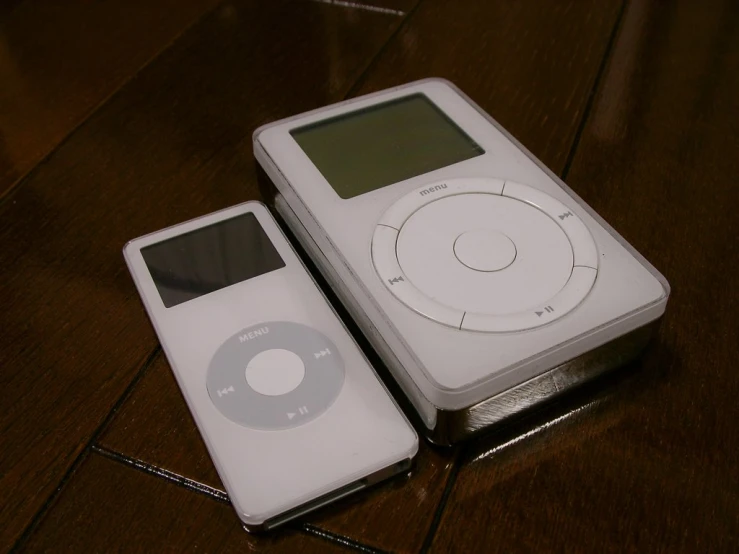 a couple of white mp3 players sitting on top of a table