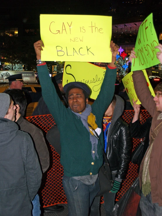 a group of protesters holding signs in front of a building