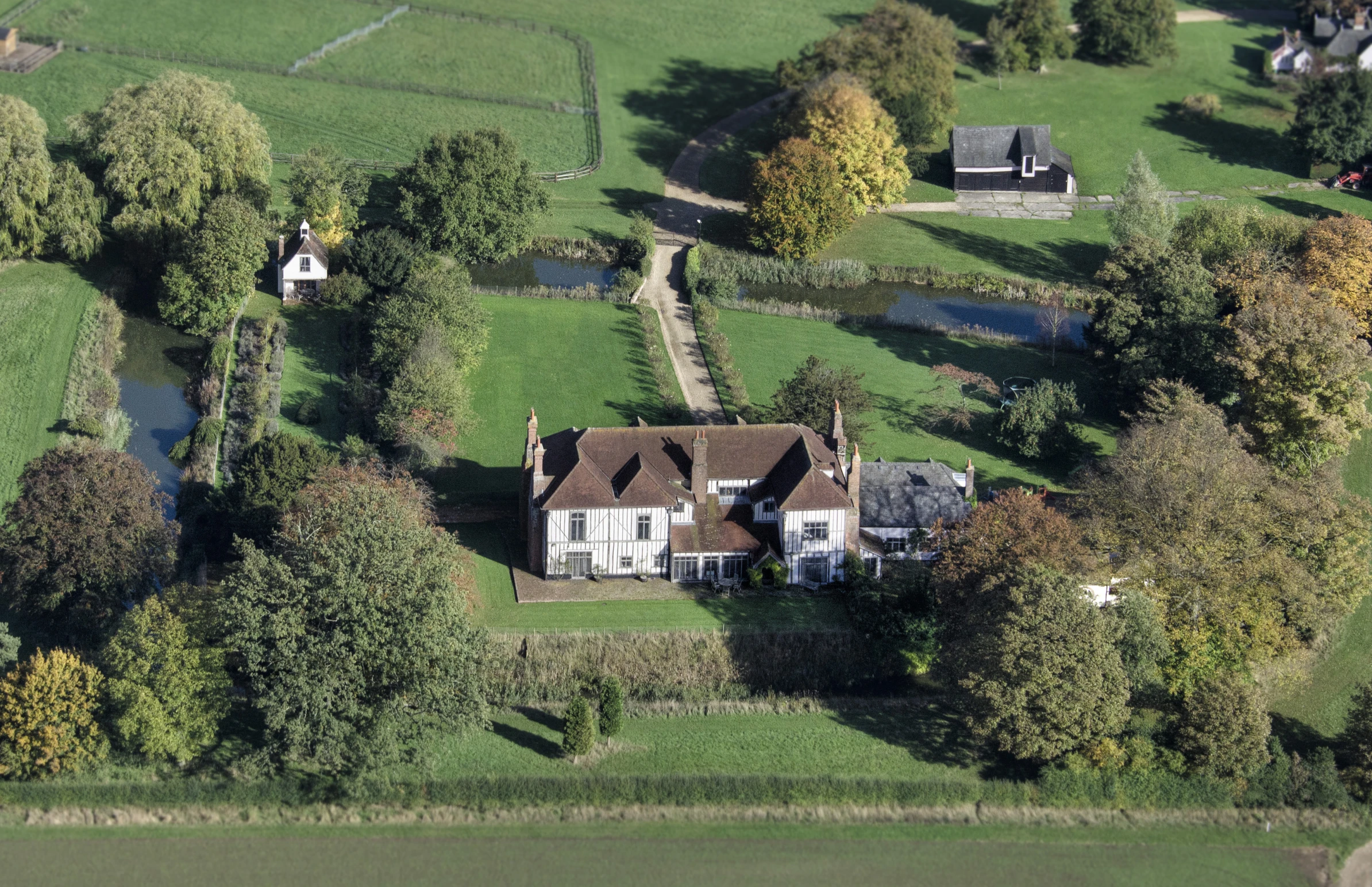 a bird - eye view of an aerial s of a house in a lush green field