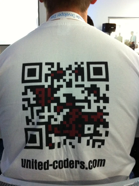 a man wears a t - shirt with a qr code printed on the back