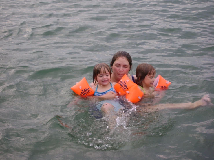 a woman and two children are in the water
