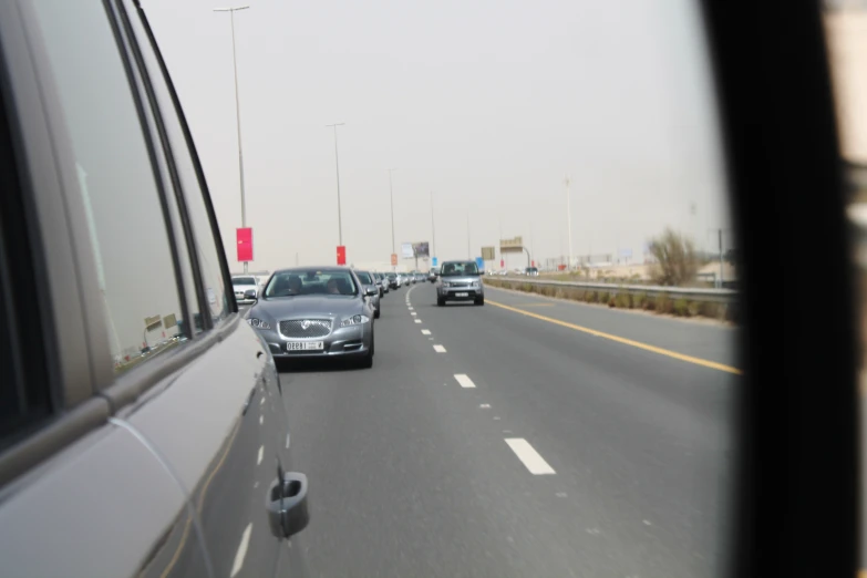 the rear view mirror of a car driving down a freeway