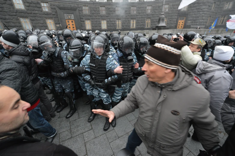 many men wearing riot gear are on the streets