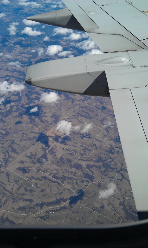 an airplane wing that is flying high up in the sky