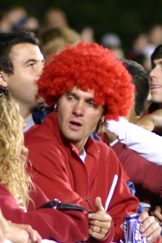 a person with red hair and a funny expression in a crowd