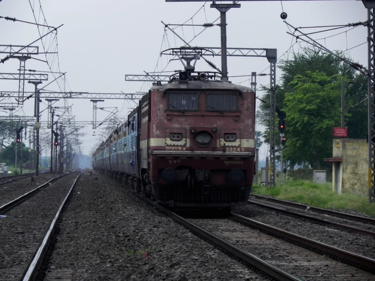 red electric train on tracks in a foggy area