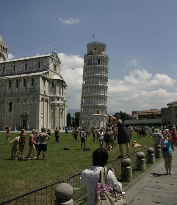 people in front of a large building with towers and flags