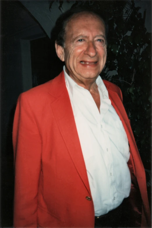 a person with a red jacket standing next to a plant