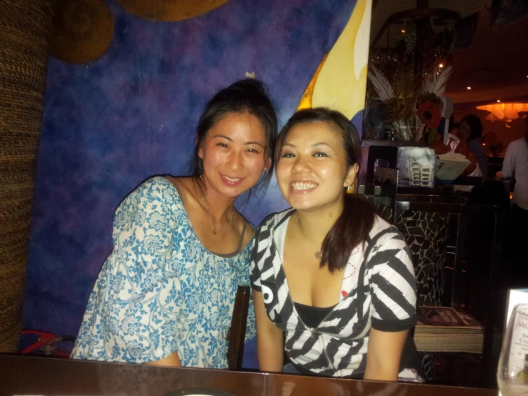 two girls are sitting at a table at a restaurant