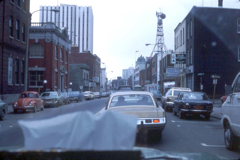 cars travelling through an intersection with traffic signs in the background