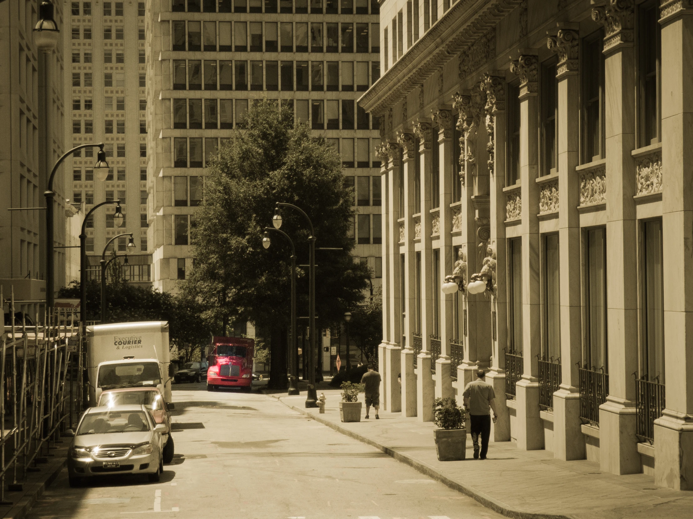 two cars parked in the street beside a tall building