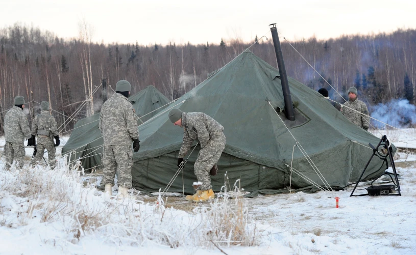 a group of men putting up tents in the snow