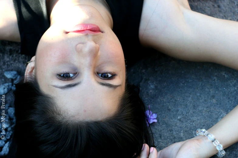 a woman laying on the ground with her eyes open