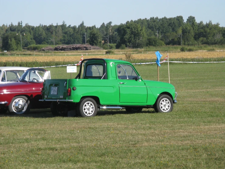 two trucks with a red and one white are parked in the grass