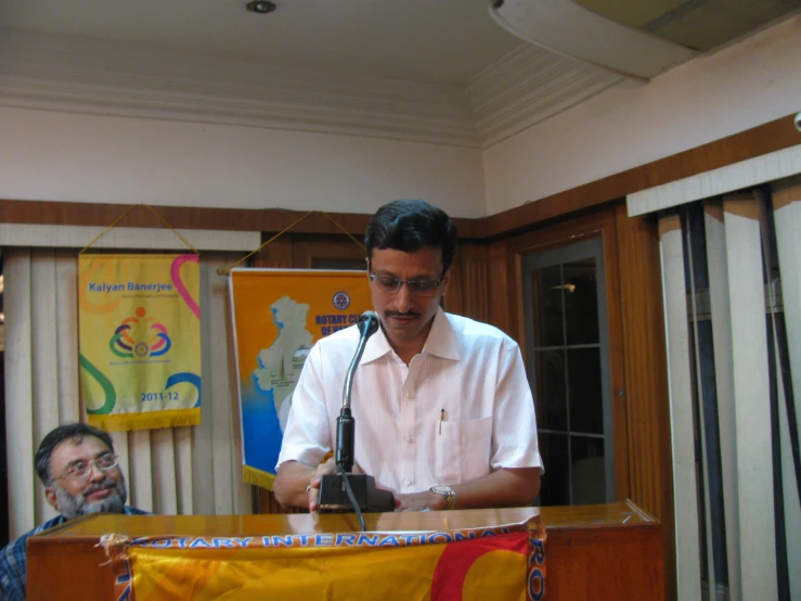 a man standing behind a microphone in front of a woman