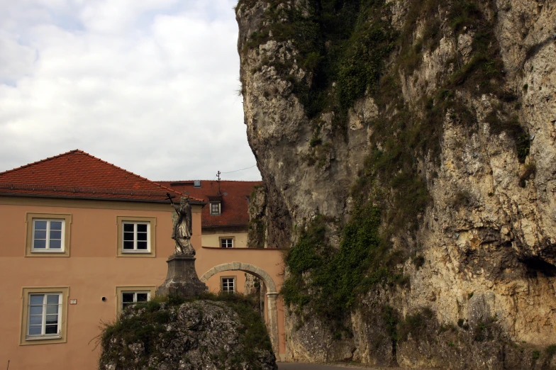 a very large building sitting below a huge cliff