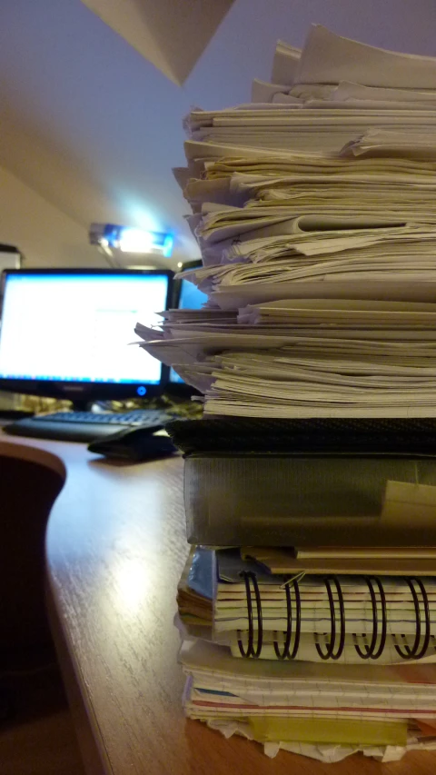 there is a pile of paperwork that is sitting on the desk