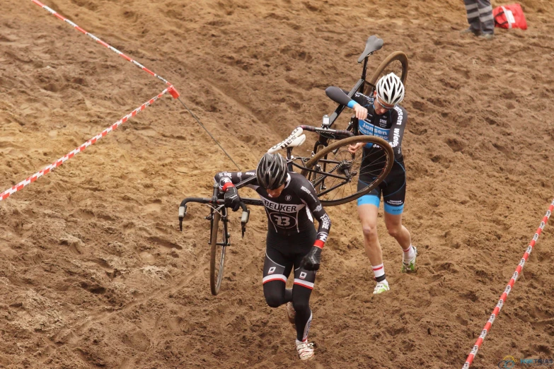 a couple of people riding bikes across a dirt field