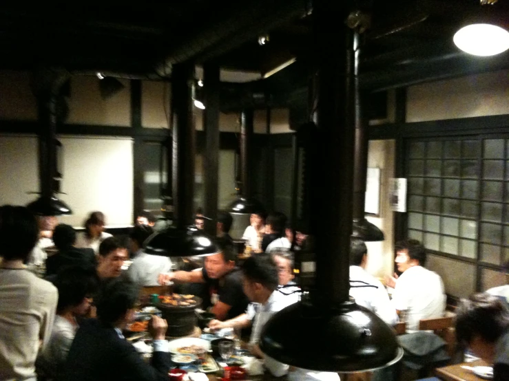 a large group of people eating at tables in a room