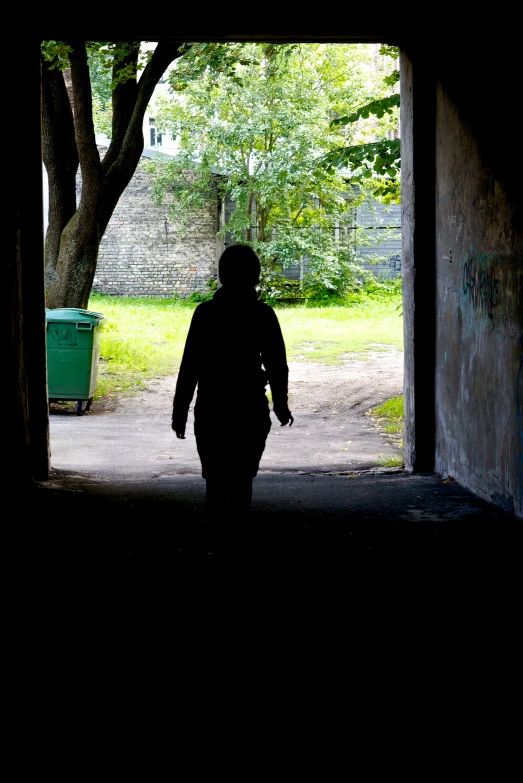 person walking into the entrance of a cave