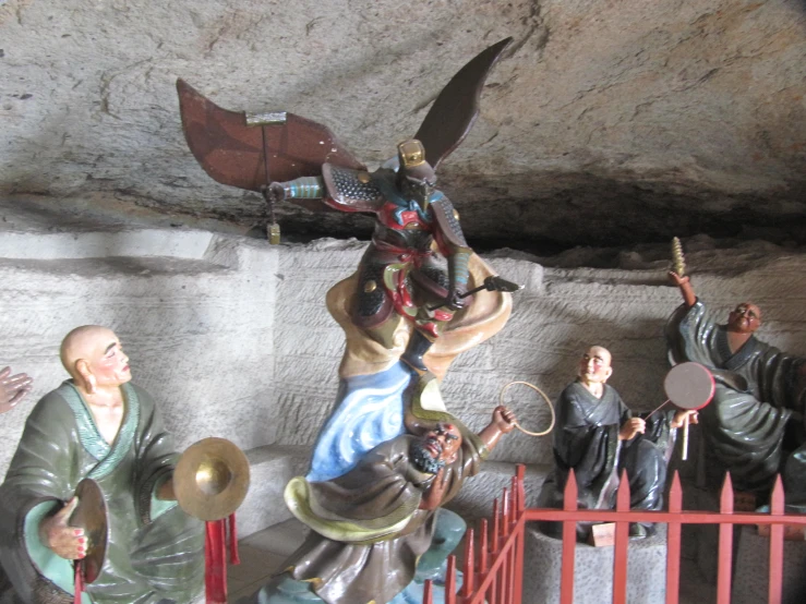 statues of people, holding instruments and a fan