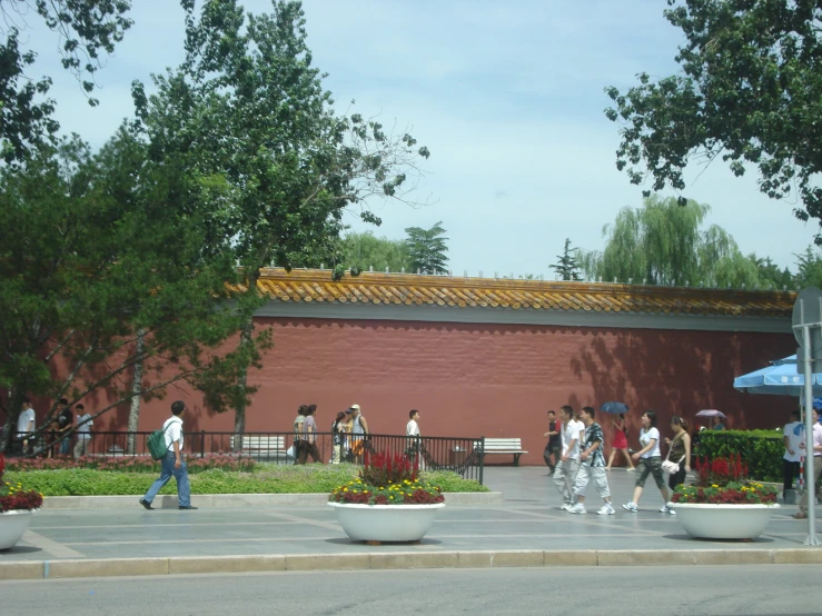 there are people walking and a woman with a blue umbrella is standing in the street