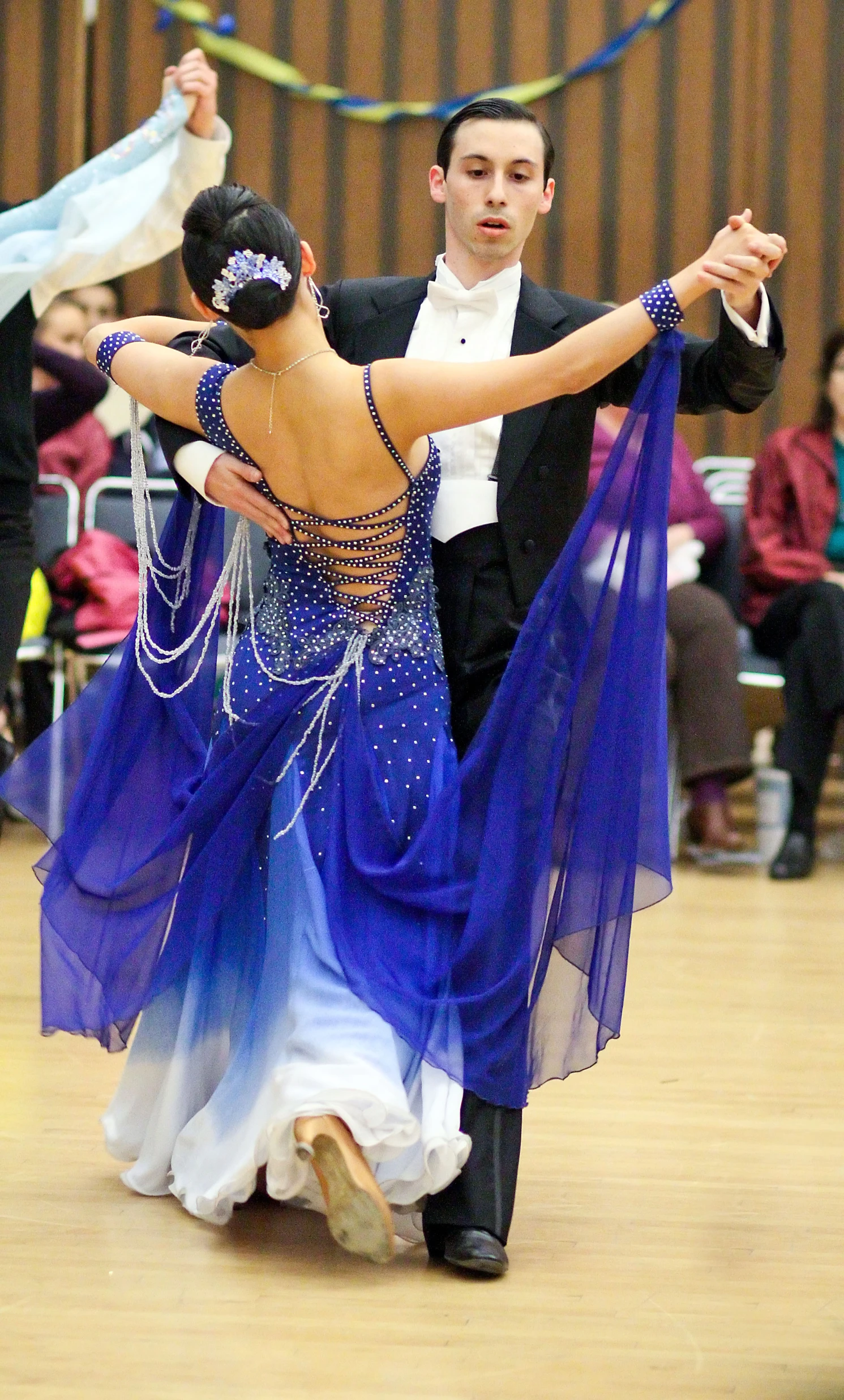 two ballroom dancers in front of a crowd