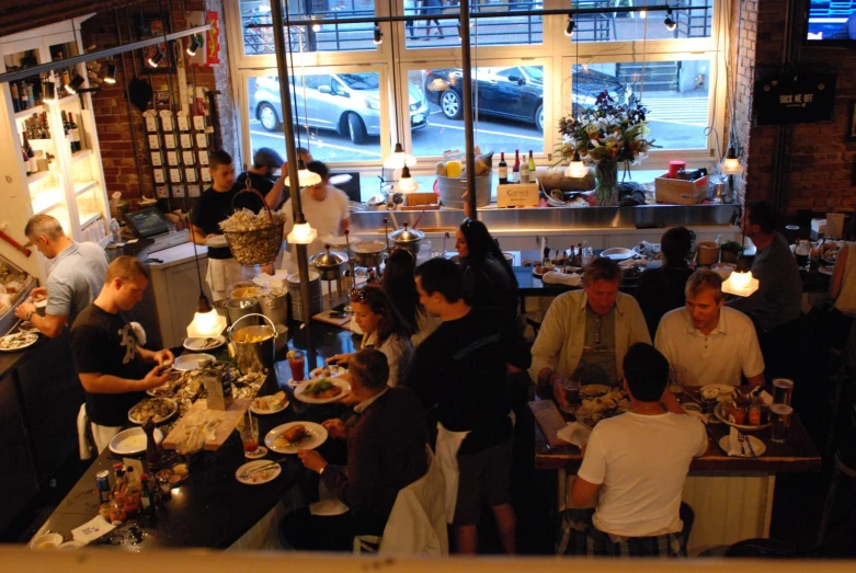 a group of people sit at tables eating