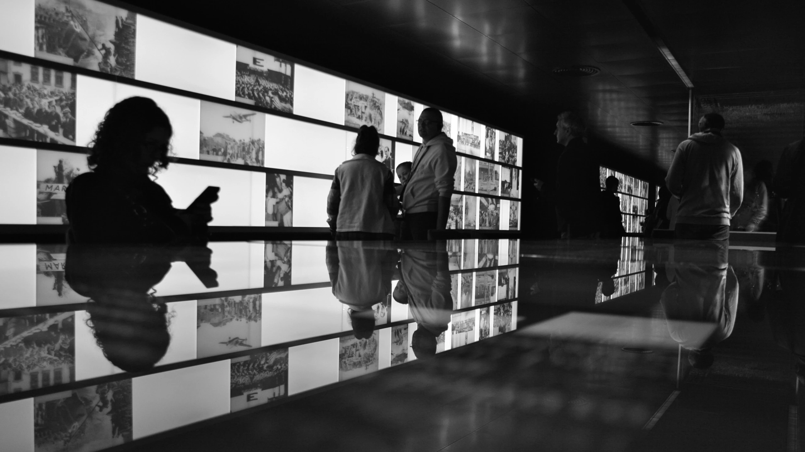 two people are looking at pictures on a wall