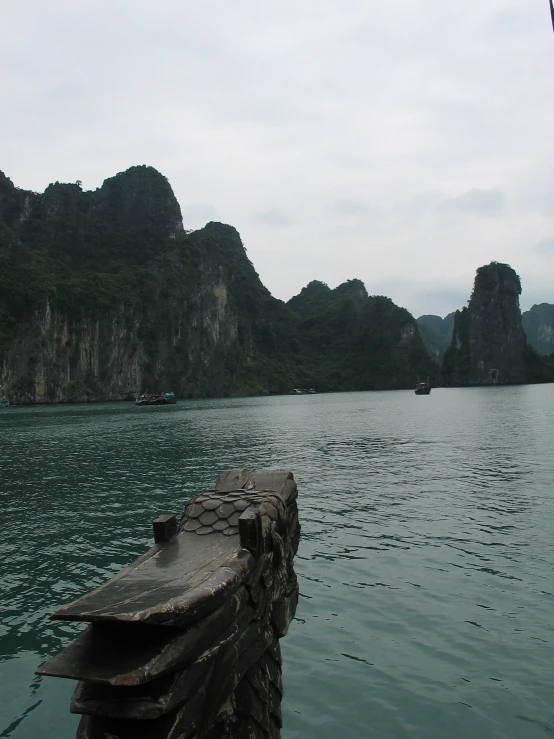 a boat on the water with some mountains in the background