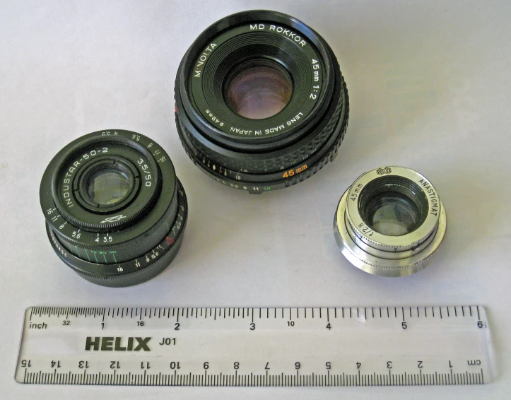 three lenses are laid next to a ruler