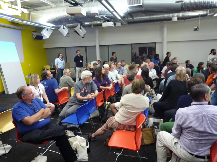 the large crowd is standing and sitting inside the building