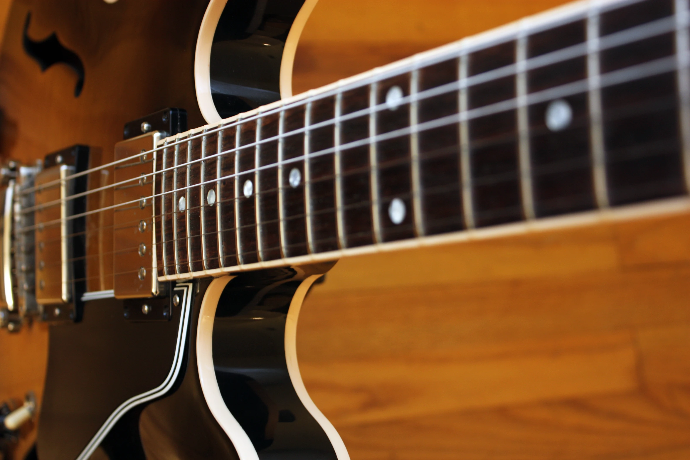 a closeup of the frets of an acoustic guitar