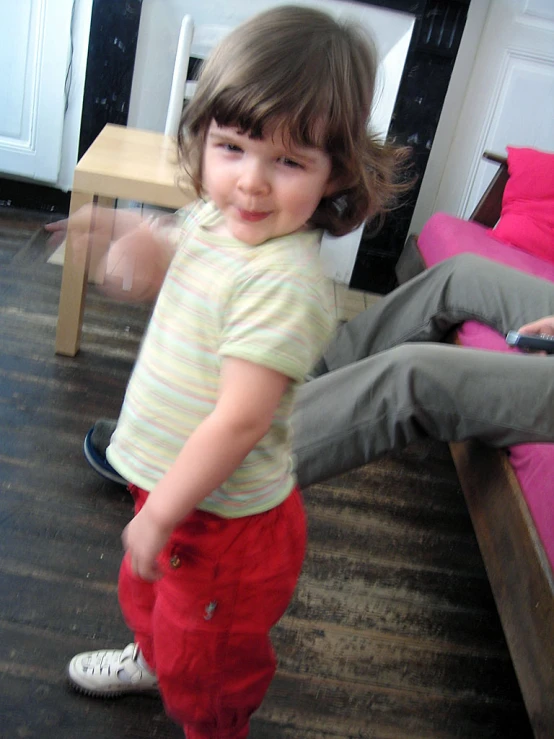 a small child in striped shirt playing with a cell phone